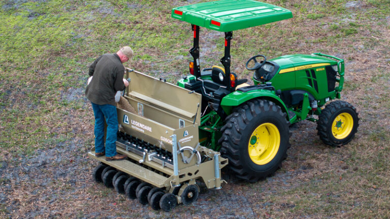 man putting seed in legendare seed drill