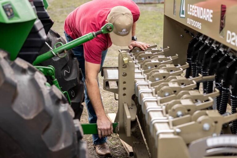 man connecting a legendare seed drill